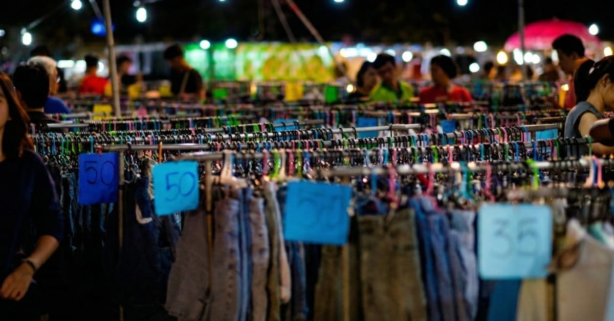 Araras de roupa e clientes de fundo na feira da madrugada sp