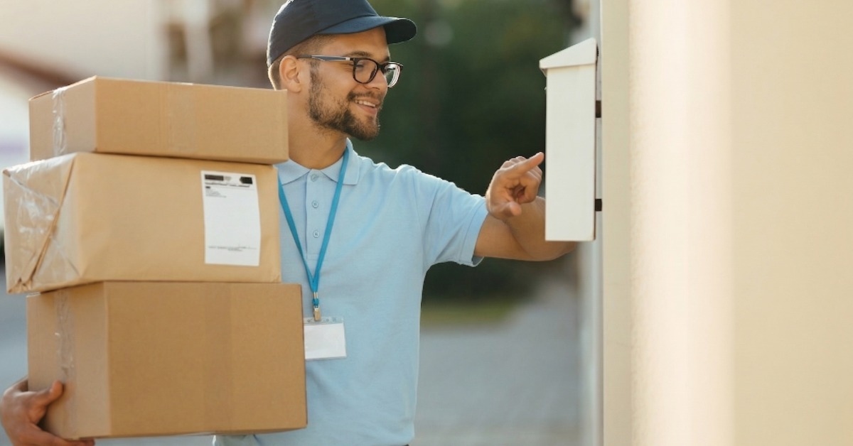 Entregador com caixas de encomenda em entrega door to door tocando o interforne